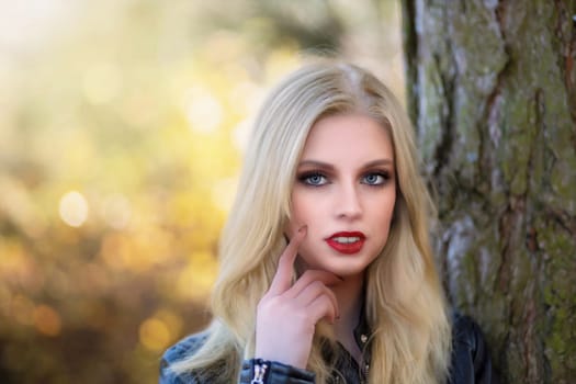 Sexy long hair girl with red lips is posing touching face by finger.  Horizontally.