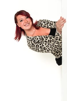 Young lovely red-haired woman looking around the corner, fashion, tiger look, on white background
