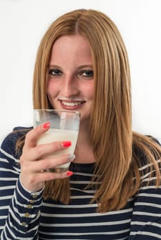 Smiling young girl drinking a glass of milk on a white background