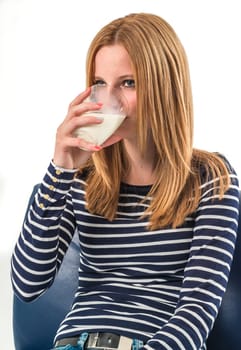 Smiling young girl drinking a glass of milk on a white background