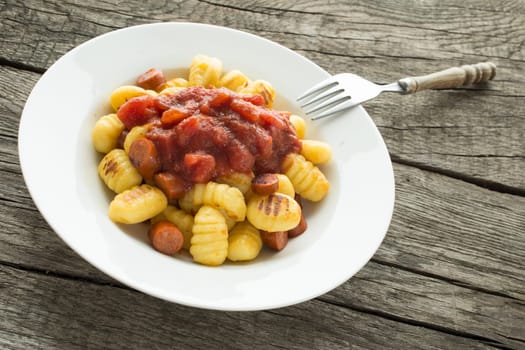Plate of gnocchi with tomato sauce and fork