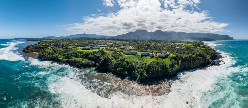 Drone aerial view of Princeville resorts from Sealodge Beach to Na Pali mountains of Kauai in winter