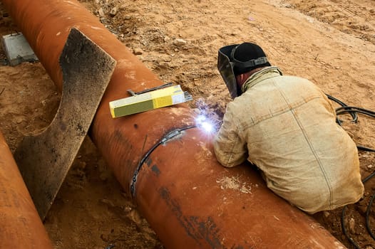 The welder welds the pipe by electro welding. High quality photo