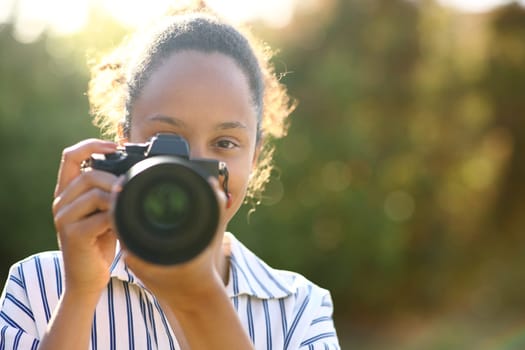 Front view of a black photographer taking photo of you