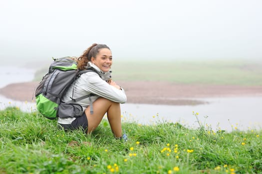 Hiker a foggy day sitting and contemplating resting in nature