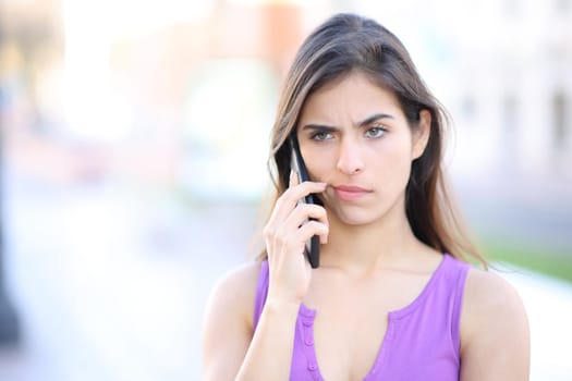 Suspicious woman attending phone call in the street