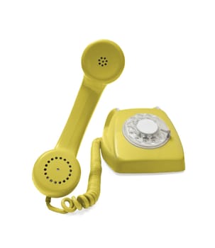 Old yellow rotary phone hook and ready to talk