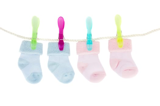 blue and pink  baby  socks hanging on rope isolated on white