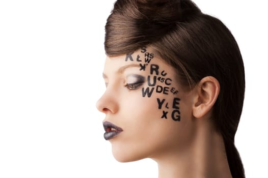 very cute young girl with letter and number painted on her face and a nice creative hair style, she is turned in profile at right and looks down
