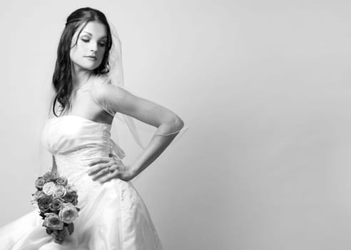 pretty brunette wearing wedding dress on light background