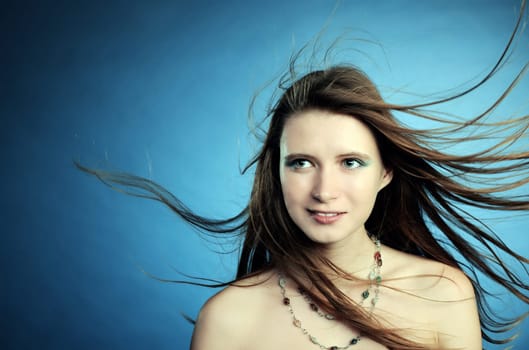 beautiful girl with long hair on blue background