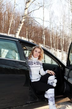 Young woman in the car. Winter forest