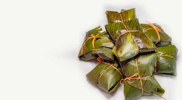 View of homemade Nicaraguan nacatamales with banana leaf on white background, Traditional food Mexican Nacatamales isolated. Traditional Nacatamales in banana leaves isolated