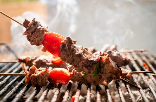 Grilled meat skewers. Close up of homemade roast beef on the grill, Roast beef skewer with tomato. Details of a delicious homemade roast beef