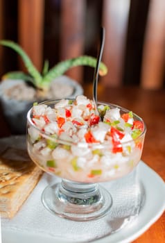 Shrimp cocktail served on wooden table, close up of a shrimp cocktail with crackers on wood