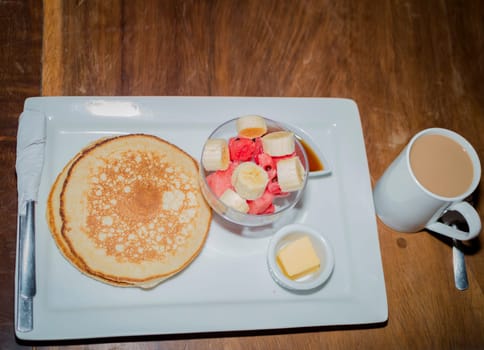 Omelet breakfast with fruit salad served on a wooden table, healthy breakfast concept with COPY SPACE