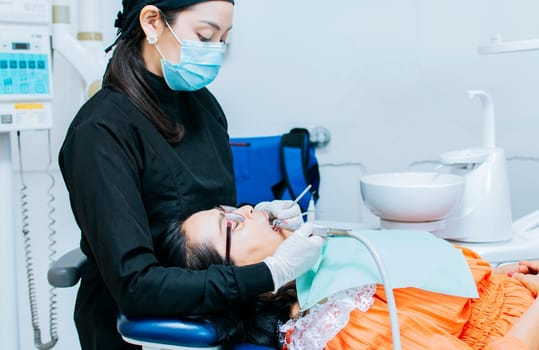 The stomatologist cleaning a patient's teeth, a dentist cleaning a patient's mouth, a dentist cleaning a patient's caries, a dentist cleaning a patient's mouth