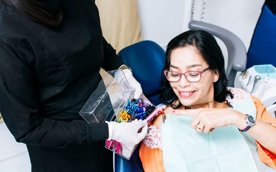 Patient with dentist choosing dental braces, Dentist with patient choosing metal braces, Patient with dentist choosing rubber band
