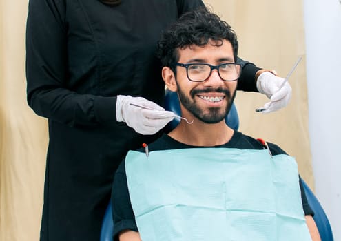 Dentist examining mouth to smiling patient, Female dentist doing root canal to female patient, Female dentist with lying patient, Dentist performing stomatology