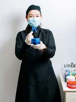 A dentist holding retainers, Female dentist holding dental retainers, Portrait of a female dentist holding retainers