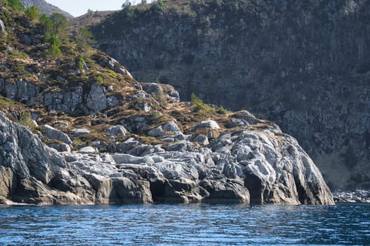 Norway, mountain reaches into fjord. Steep slopes in the background. Fjord landscape. Landscape photo from the north
