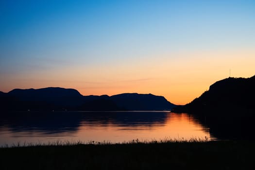 Fjord with view of mountains and fjord landscape in Norway. Landscape shot in the evening in the north with bright sky.