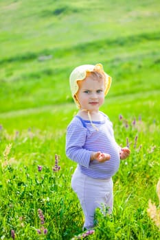 Portrait of 1 year old baby girl enjoying a day on a meadow.