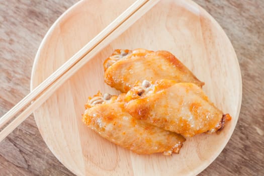 Grilled chicken wings on wooden plate, stock photo