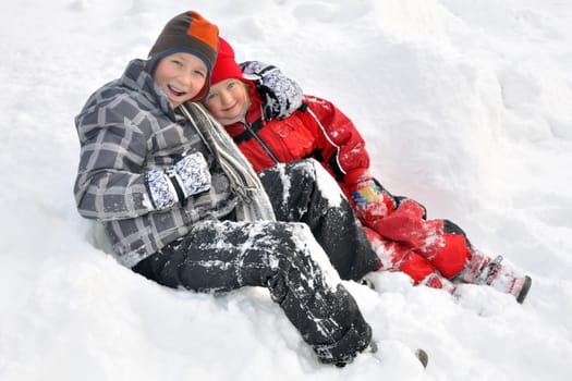 2 siblings lie in the shee after romping around