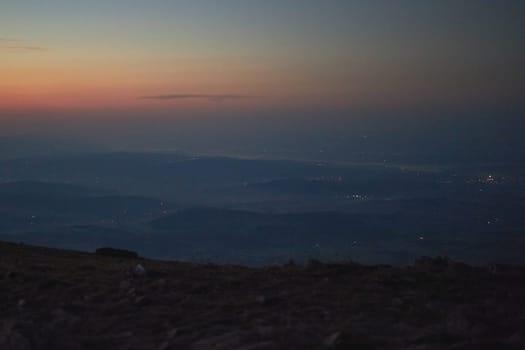 Mountains at sunrise. Natural mountain landscape with illuminated misty peaks, foggy slopes and valleys, blue sky with orange yellow sunlight. Amazing scene from Beskid Zywiecki in Poland