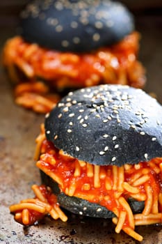 closeup of charcoal bun spaghetti sandwich