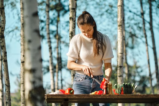 Woman peeling seeds from bell pepper while making food outdoor