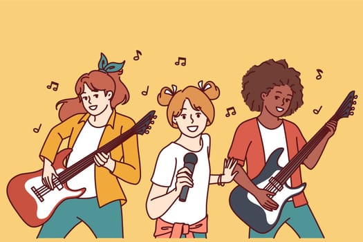 Musical group of teenage girls with guitars and microphone performing at amateur concert of rock culture. Diverse girls perform at entertainment musical event with desire to become popular singers
