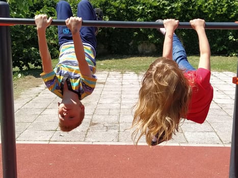 Sremska Mitrovica, Serbia. June 6, 2020. Flip-flops, weight lifting and weights, strength exercises. Two teenagers go in for sports on simulators, children on a sports ground.