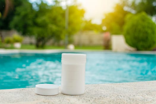 Chlorine tablets kit in the edge of a swimming pool, chlorine tablets for swimming pool disinfection, Chlorine tablets for swimming pool cleaning and maintenance,