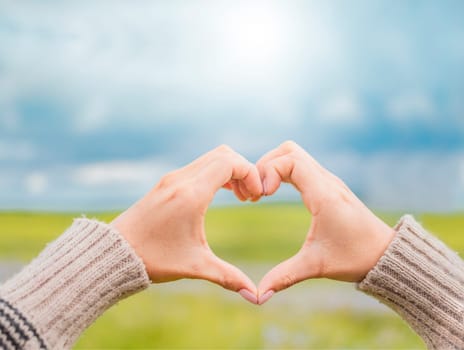 Hands together in a heart shape, woman's hands together in a heart shape, hands making a heart shape