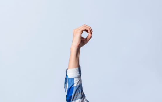 Hand gesturing the letter O in sign language on an isolated background. Man's hand gesturing the letter O of the alphabet isolated. Letter O of the alphabet in sign language