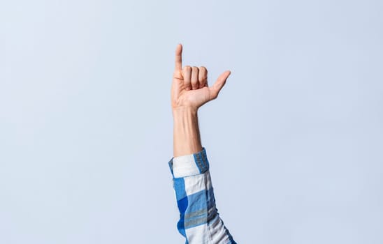 Hand gesturing the letter Y in sign language on an isolated background. Man's hand gesturing the letter Y of the alphabet isolated. Letter Y of the alphabet in sign language