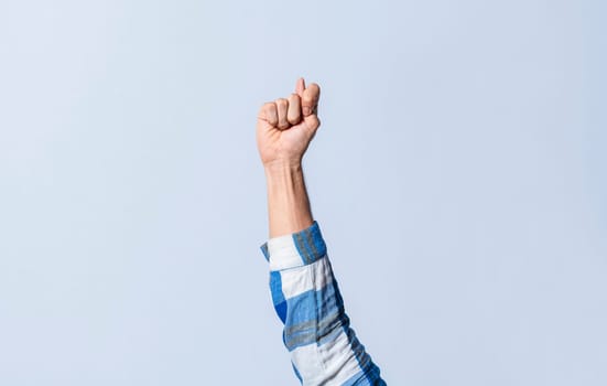 Hand gesturing the letter T in sign language on an isolated background. Man's hand gesturing the letter T of the alphabet isolated. Letter T of the alphabet in sign language