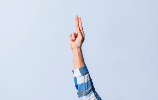 Hand gesturing the letter U in sign language on an isolated background. Man's hand gesturing the letter U of the alphabet isolated. Letter U of the alphabet in sign language