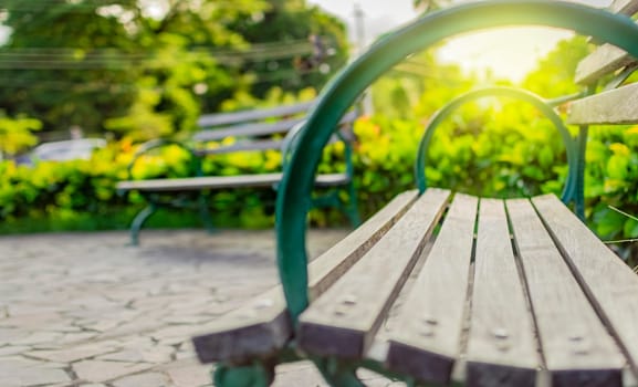 Low angle view of a lonely bench in the park with out of focus background, Wooden bench with blur background with copy space. low angle view of a bench in a park
