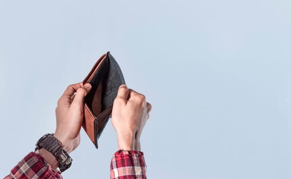 Concept of an empty wallet, hand opening empty wallet on isolated background, concept of economic crisis