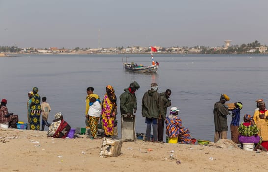 Dakar, Senegal. August 18, 2019: People buying and selling just landed fish on beach at Dakar, Senegal, West Africa
