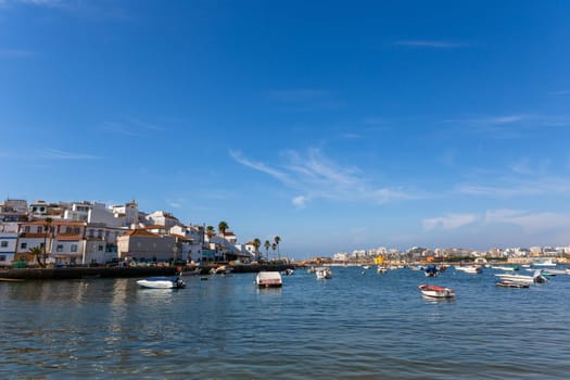 Ferragudo, Portugal - August 25, 2022 - View of the white town with boats moored in the foreground, Ferragudo, Algarve, Portugal, Europe