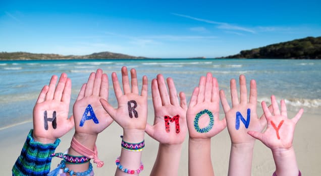 Children Hands Building Colorful English Word Harmony. Summer Ocean, Sea And Beach As Background