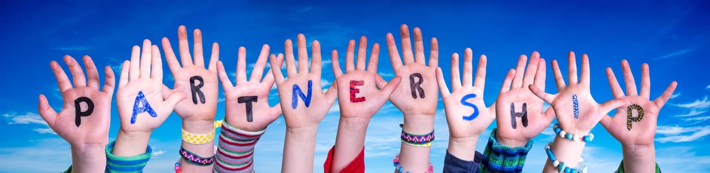 Children Hands Building Colorful English Word Partnership. Blue Sky As Background