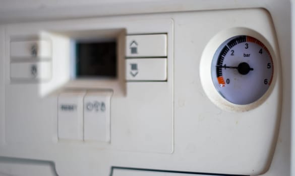Gas pressure meter on the panel of the heating gas boiler. Symbolic image of the heating season at home. Dial and pressure gauge on combi boiler. Hot water and heating. Boiler accessories