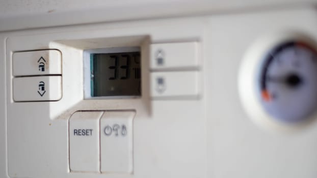 Gas pressure meter on the panel of the heating gas boiler. Symbolic image of the heating season at home. Dial and pressure gauge on combi boiler. Hot water and heating. Boiler accessories