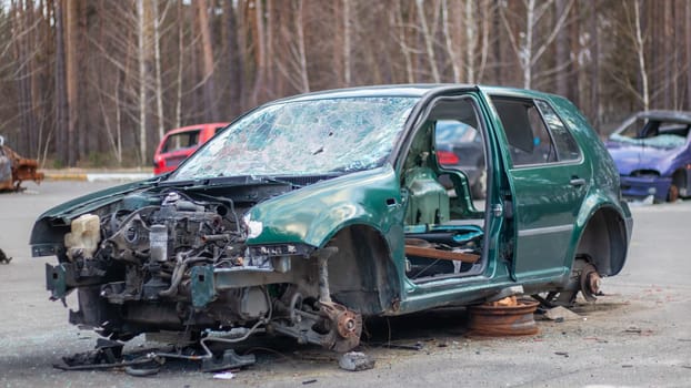 Broken crumpled car after a severe accident with a skewed body, after a powerful impact on the side of the road. Traffic accident on the street, damaged car after a collision in the city