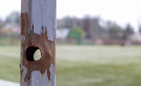Bullet hole in the pipe. War in Ukraine. A hole from a shell fragment. Consequences of the war. Holes from shots on a metal pipe